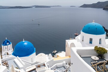 Fototapeta na wymiar White churches with blue domes in Oia overlooking the sea
