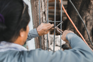 Fototapeta na wymiar construction workers using wire cutter pliers and steel wire to binding wire in reinforcement reinforced concrete structures ,construction and industry concept