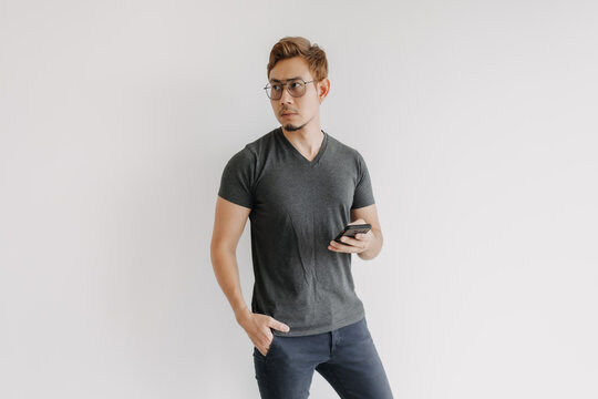 Cool asian man with color hair and eyeglasses using phone application.
