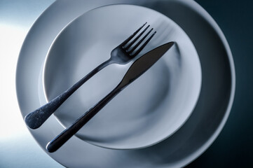 paired fork and knife on a pair of clean white plates
