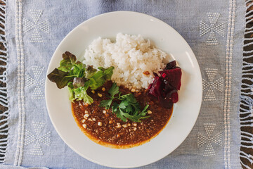 Japanese curry rice with pickles served on white dish in the restaurant.