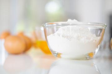 Fresh ingredients for delicious homemade cake on white  table and kitchen background. ingredients and tools to make a cake, flour, butter,eggs