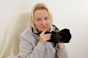 pensive real simple woman holding a camera in sports suit on an armchair with a plaid woolen plaid comfort at home thoughts expectations from life