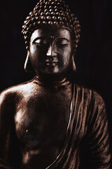 Meditating Buddha Statue on dark background. Soft focus. Close up. Copy space.	