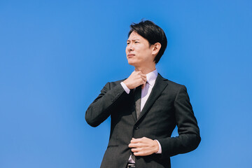 ネクタイを整える日本人男性ビジネスマン