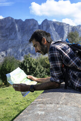 A hiker looking at a map in a sunny day.