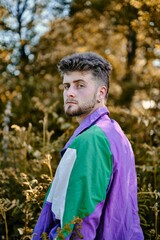 Vertical shot of a caucasian man staring at the camera against blurred background