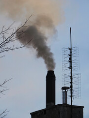 Black smoke from the chimney with antennes 