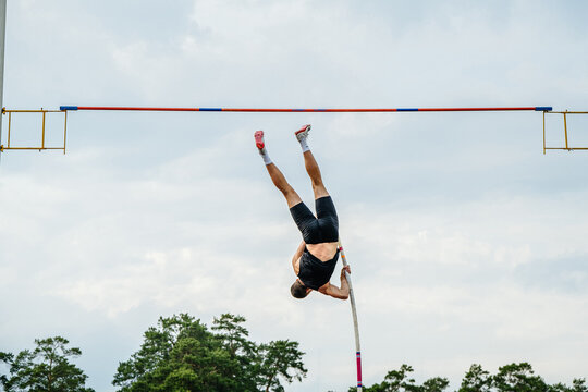 back male athlete pole vault in sky background, Nike spikes shoes and socks, summer sports games