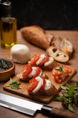 Bruschetta with tomatoes, basil and mozzarella on a wooden table