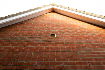Vertical aspect of the recent brick built home exterior. Showing an isolated extra fan vent leading...