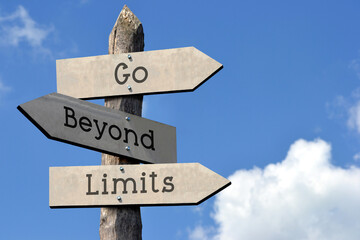 Go beyond limits - wooden signpost with three arrows, sky with clouds