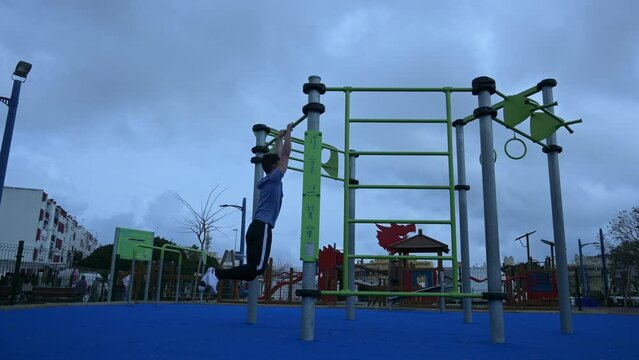 Caucasian man doing pull-ups on the bar and falling down