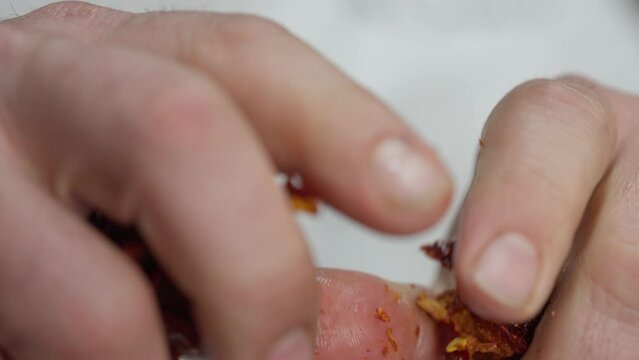 Closeup of a person breaking a dry chili pepper in half