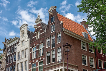 Fototapeta premium Amsterdam street in summer with colorful houses in classic holland architecture