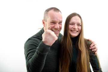 Victory win very satisfied faces of adult man and young woman he hugs girl clenched fist with joy shows we won Our victory on white background result of game football match end of project successful