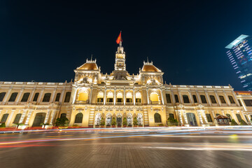 Fototapeta premium Traffic in front of Ho Chi Minh City Hall, Saigon City Hall or Committee Head office in the evening, Vietnam. Light trail and night. Popular place to visit in Saigon