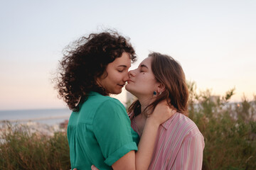 two lesbian girls in love watch the sunset on gay pride day