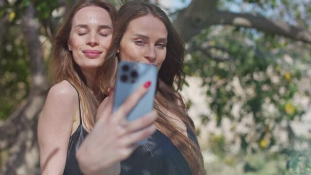 Identical twins with mobile phone for selfies