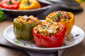 Stuffed peppers, halves of peppers stuffed with rice, dried tomatoes, herbs and cheese in a baking...