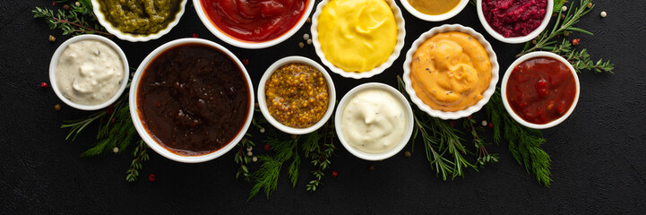 Different types of sauces in bowls with seasonings banner, rosemary and dill, thyme and and peppercorns, top view, copy space