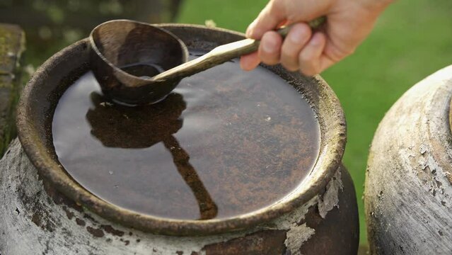 Bali, Pura Linga Bhuvana, traditional things in the temple for sacrifices. A vessel for water, a man's hand performs a rite