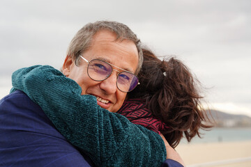 business father and daughter talking affectionately outside looking at camera. Father's day