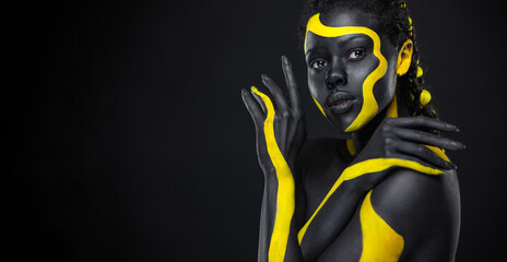 African woman with art fashion makeup. Download high resolution Picture with black and yellow body paint on african woman for your Music track or website design. Create album cover with creative Image