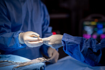 Team of surgery doctor in Operating Room hold hands scalpel surgical blade give to Surgeons During...