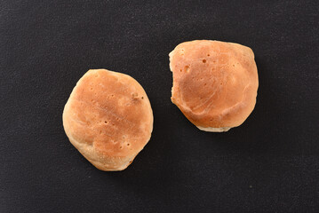 Fototapeta na wymiar Two loaves of bread on the dark background.