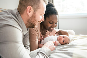 A Portrait of a beautiful family, with her nursing baby on bedroom