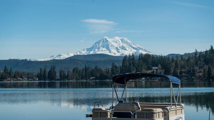 Clear lake and pontoon boat with Mount Rainier, Washington landscape in winter
