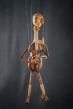 Handmade violoncello or violin like puppet on black background