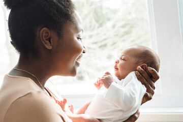 A Portrait of a beautiful black mother, with her nursing baby - obrazy, fototapety, plakaty