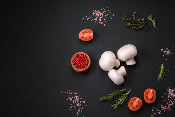 Fresh raw champignon mushrooms on a wooden cutting board with spices