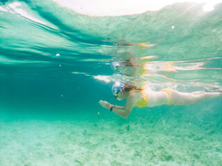 woman snorkeling in clear tropical sea