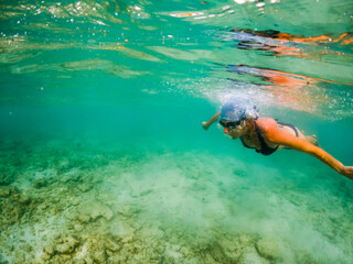 woman snorkeling in clear tropical sea