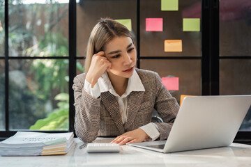 Asian women are stressed while working on laptop, Tired asian businesswoman with headache at office, feeling sick at work