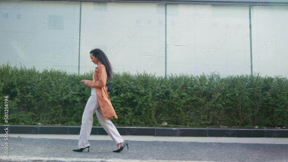 Sticker Happy, walking and woman with a phone in the city for social media, communication and gps location. Smile, street and girl on a 5g mobile app while commuting in town for travel and online chat