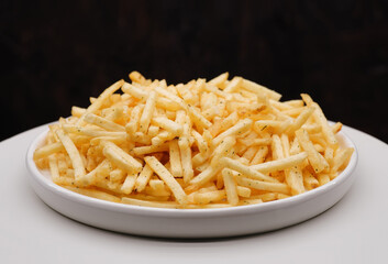 French fries background, closeup shot. Delicious potatoes with a golden fried crust. French fries background. Potato straw