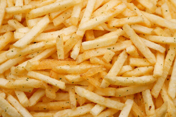 French fries background, closeup shot. Delicious potatoes with a golden fried crust. French fries background. Potato straw