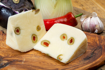 Cheese collection, fresh Italian pecorino cheese made from sheep milk filled with green olives stuffed with red sweet paprika