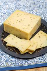 Cheese collection, piece of cow milk Dutch gouda cheese with dried aromatic cumin seeds close up