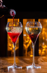 Drinking of Kir Royal, French aperitif cocktail made from creme de cassis topped with champagne, typically served in tulip glasses