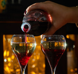 Drinking of Kir Royal, French aperitif cocktail made from creme de cassis topped with champagne,...