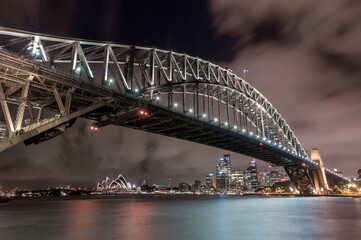 Obraz premium Sydney Harbour Bridge and Opera House at Night. Beautiful Sydney Cityscape and Skyline. Long Exposure. Flowing Sky. Australia