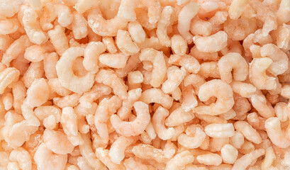 Frozen orange shrimps background. Macro texture of cooked peeled prawn tails. Sea crustacean for...