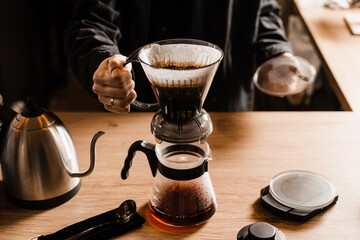 Clever coffee dripper with pour over filter and accessories on the wooden table in cafe. Drip...