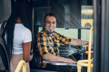 Fototapeta na wymiar Bus driver behind the wheel of a public transport vehicle