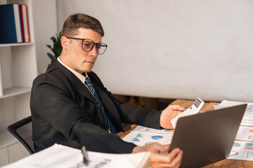 Portrait of business man working on analysis finance statistics and planning in a office. Make an account analysis report. real estate investment information financial and tax system concepts